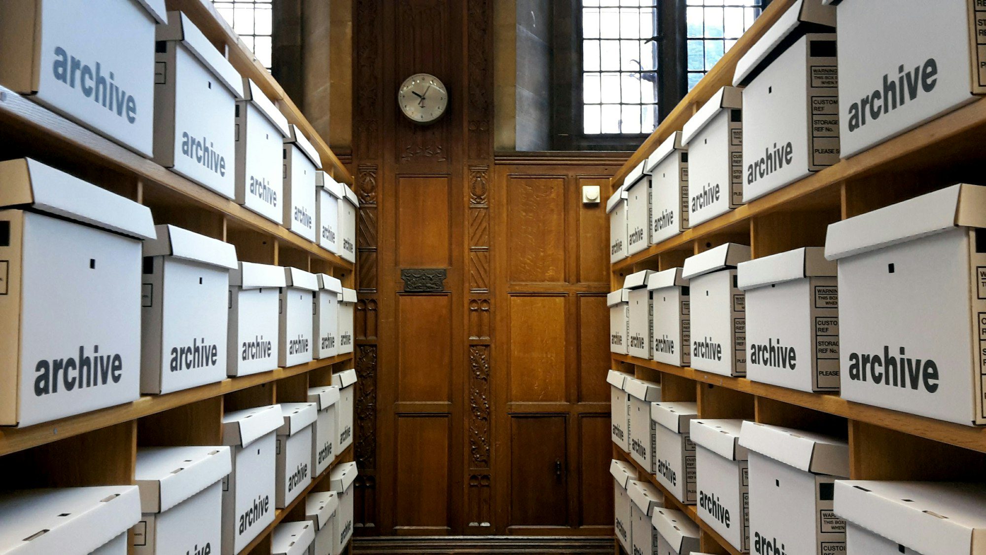 Couloir d’archives : boîtes alignées sur des étagères
