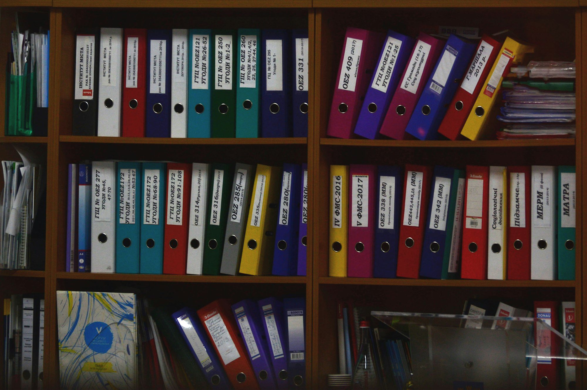 Rangées de classeurs colorés sur des étagères